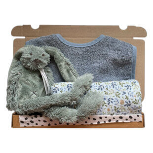 Kleine-kapitein-cadeaubox: Een prachtig kraamcadeau met een zachte groene knuffel, een blauw slabbetje en een vrolijk bloemenprintdoekje – ideaal voor pasgeboren baby’s.