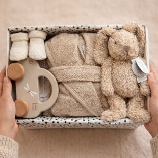 stijlvolle kraamcadeau set combineert zachte baby essentials met een badjasje