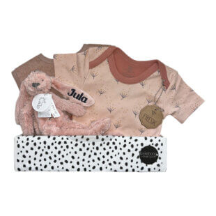 Een liefdevol samengesteld kraampakket voor een meisje met romper, knuffeldoekje Richie en een badstof slab in zachte tinten.